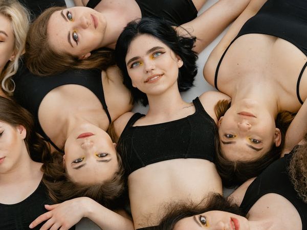 Diverse group of people smiling during a yoga practice in a studio.